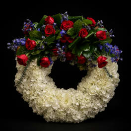 Heart-shaped floral wreath with white hydrangeas, red roses, and purple flowers