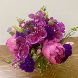 Pink and purple bouquet with orchids and peonies on a table