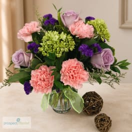Bouquet of pink, lavender, and purple flowers in a glass vase