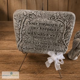 Decorative memorial plaque with a white ribbon on a stand