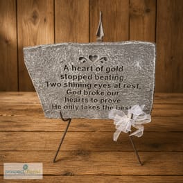 Memorial stone plaque on a metal stand with a white ribbon bow
