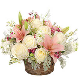 Pink lilies and white roses in a wicker basket