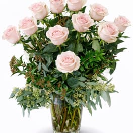 Arrangement of pale pink roses in a clear glass vase