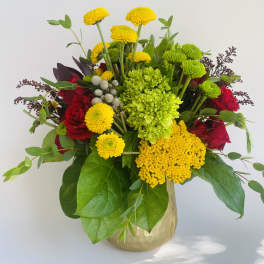 Mixed bouquet of red roses and yellow chrysanthemums in a gold vase