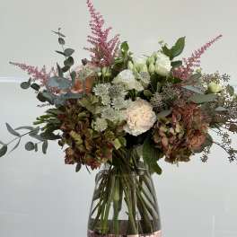 Mixed bouquet of white and blush flowers in a glass vase