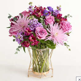 Pink and purple bouquet in a glass vase with a gold stand