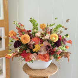 Colorful mixed flower arrangement in a white bowl vase
