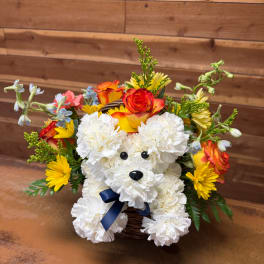 White teddy bear made of flowers in a basket with colorful blooms