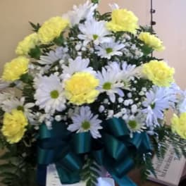 White daisies and yellow carnations in a teal ribboned arrangement
