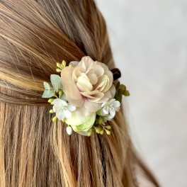 Floral hair accessory with pale peach and white blossoms in blonde hair