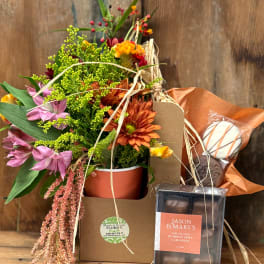 Mixed flower arrangement in a gift box with chocolates and a cookie