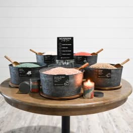 Assorted scented candles in metal tubs on a round table
