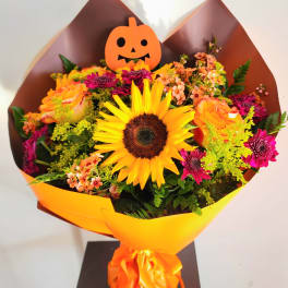 Bouquet with a sunflower, orange roses, and a pumpkin topper