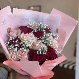 Pink and red rose bouquet wrapped in pastel pink paper