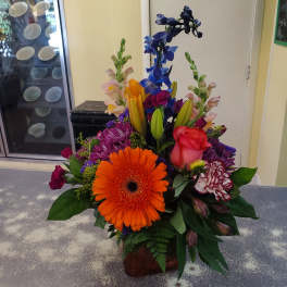 Colorful mixed flower arrangement in a low glass vase