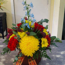 Colorful mixed bouquet with roses, chrysanthemums, and blue delphinium in a vase