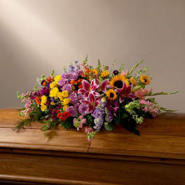 Colorful mixed flower arrangement on a wooden casket