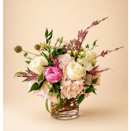 Bouquet of cream and pink roses in a clear glass vase