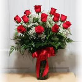 Bouquet of red roses in a glass vase with a red ribbon