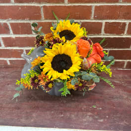 Sunflower and rose arrangement in a gray ceramic container