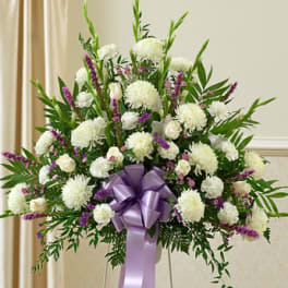 White and purple floral standing spray with a lavender ribbon