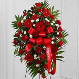 Red floral standing spray with ribbon on an easel