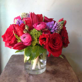 Red and pink flowers arranged in a clear glass vase