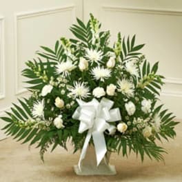 White floral spray with a large white bow on a stand