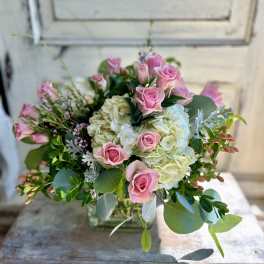 Pink roses and white hydrangeas in a clear glass vase