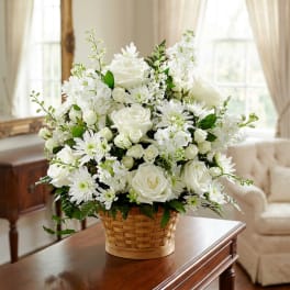 White roses and daisies arranged in a woven basket