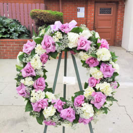 Pink and white floral wreath on a stand