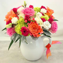 Colorful rose bouquet in a white pitcher vase