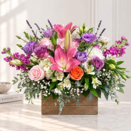 Mixed bouquet with pink lilies, purple roses, and a wooden box