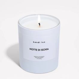 Lit white scented candle in a frosted glass jar