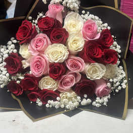 Bouquet of red, pink, and white roses with baby's breath in black wrap