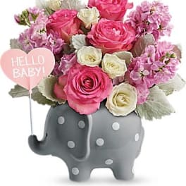 Pink and white rose arrangement in a gray polka dot elephant vase with a pink Hello Baby heart pick.
