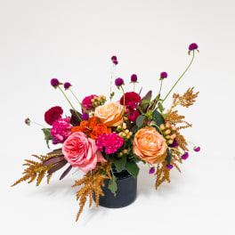 Mixed bouquet of roses and carnations in a dark vase