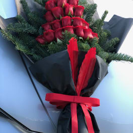 Bouquet of red roses wrapped in black paper with a red ribbon