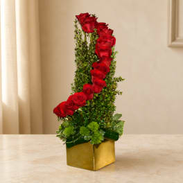 Tall red rose arrangement in a gold square vase