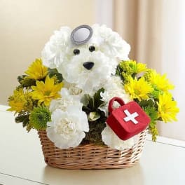 White teddy bear floral basket with yellow flowers and a red first-aid pouch