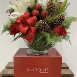 Holiday arrangement of white lilies and red roses in a glass vase