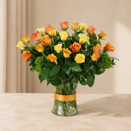 Bouquet of yellow and orange roses in a clear glass vase