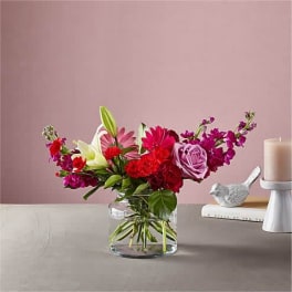 Mixed pink and red flower arrangement in a clear glass vase