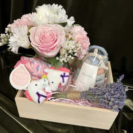 Pink rose and white daisy bouquet in a wooden gift box with baby items