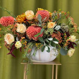 Mixed bouquet of pink dahlias and cream roses in a white vase