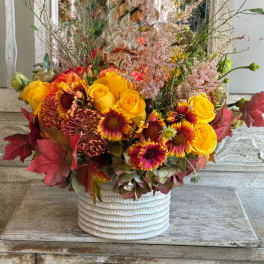 Autumn bouquet of yellow roses and burgundy daisies in a white vase