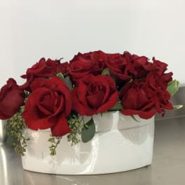Red roses arranged in a white ceramic container