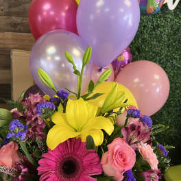 Bright mixed bouquet with yellow lily, pink gerbera, roses, and balloons