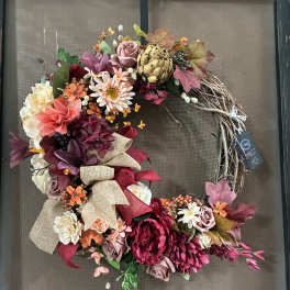 Floral wreath with pink, burgundy, and cream blooms on a twig base