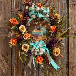 Fall wreath with orange and cream roses on a stand